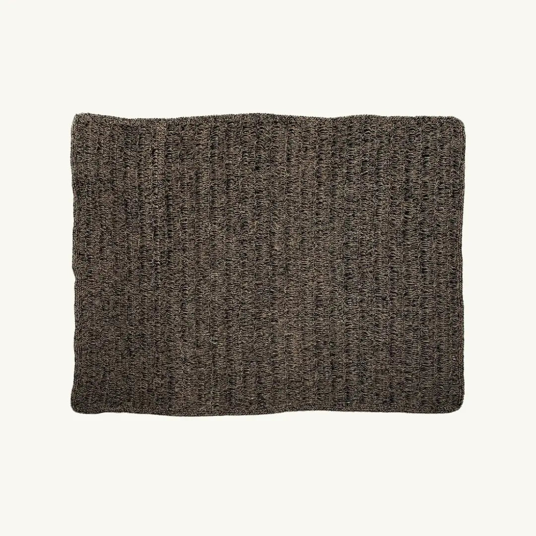 The Natural Black Seagrass Carpet featuring a rectangular shape with a striking natural and black color combination. Crafted from raffia, sisal, and palm, this rug offers both elegance and durability for any room.