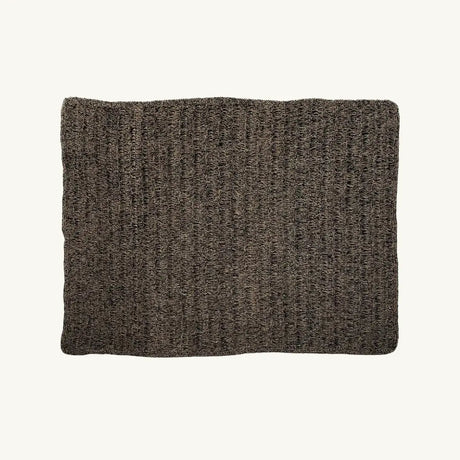 The Natural Black Seagrass Carpet featuring a rectangular shape with a striking natural and black color combination. Crafted from raffia, sisal, and palm, this rug offers both elegance and durability for any room.