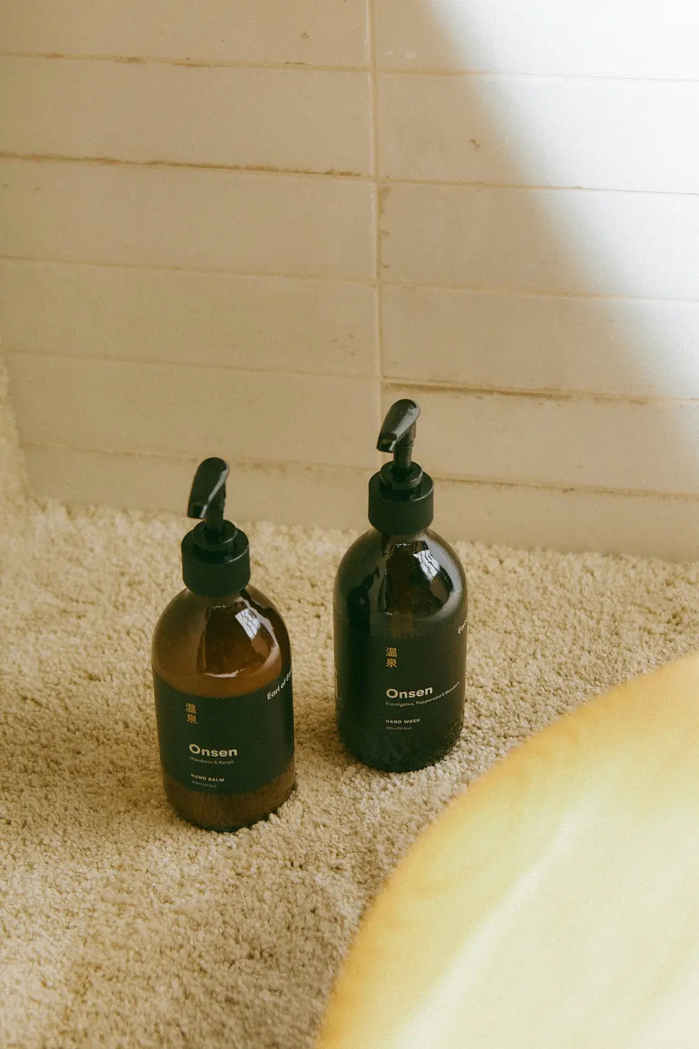 Pair of Onsen Hand Wash and Hand Balm bottles, designed to cleanse and nourish hands with a fresh, uplifting scent.