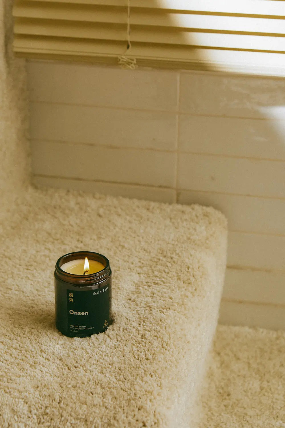 Earl of East Onsen Candle placed in a cozy home setting, creating a relaxing spa-like atmosphere.