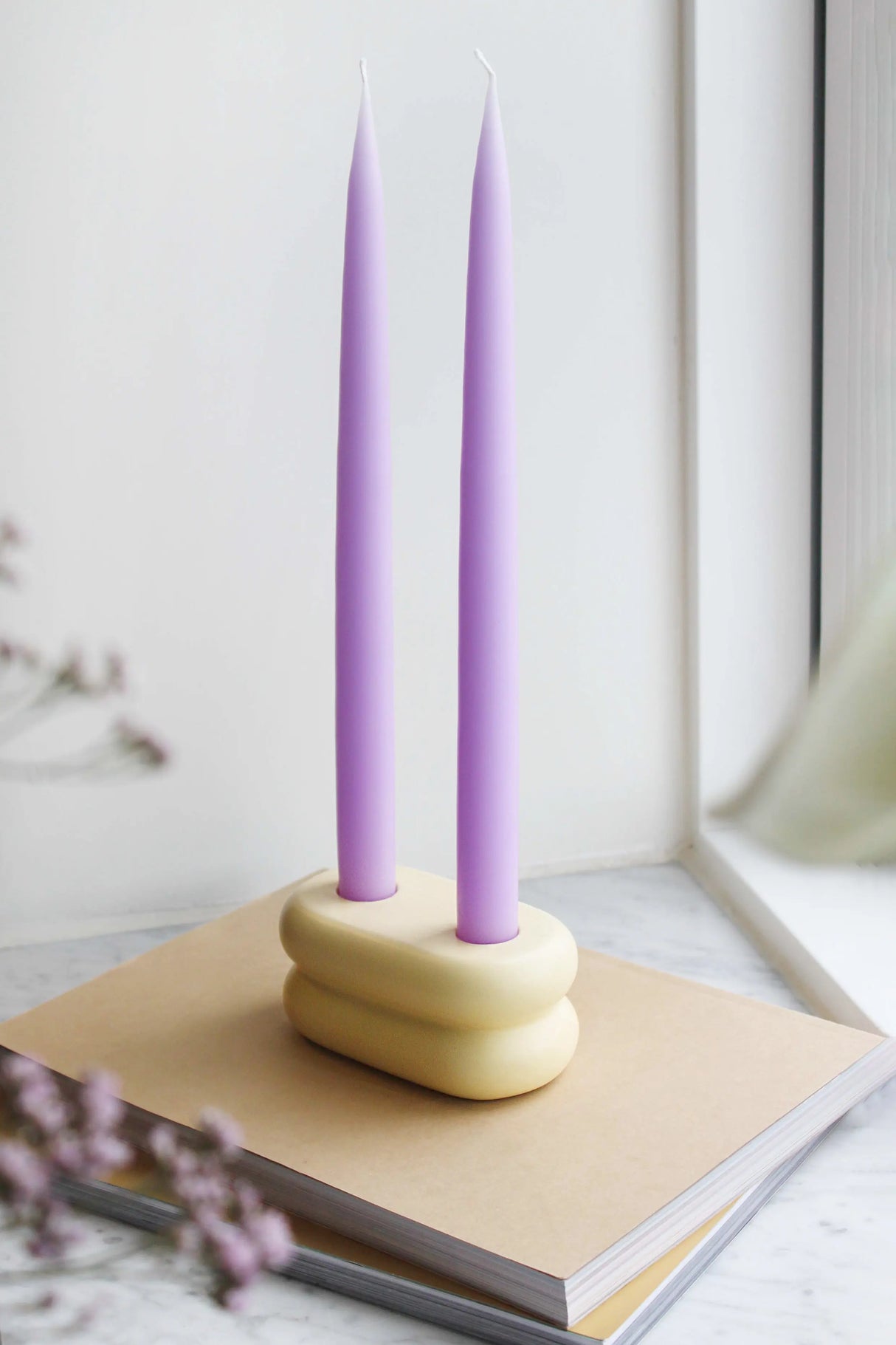 Modern ceramic candlestick with a soft matte yellow finish, featuring a playful rounded curve design