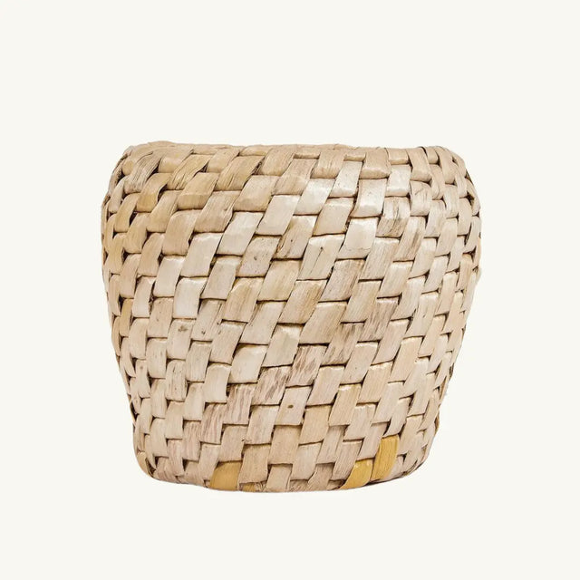 Chidi Basket placed in a living room, showcasing its eco-friendly banana leaf and water hyacinth material with a distinctive diagonal weave pattern