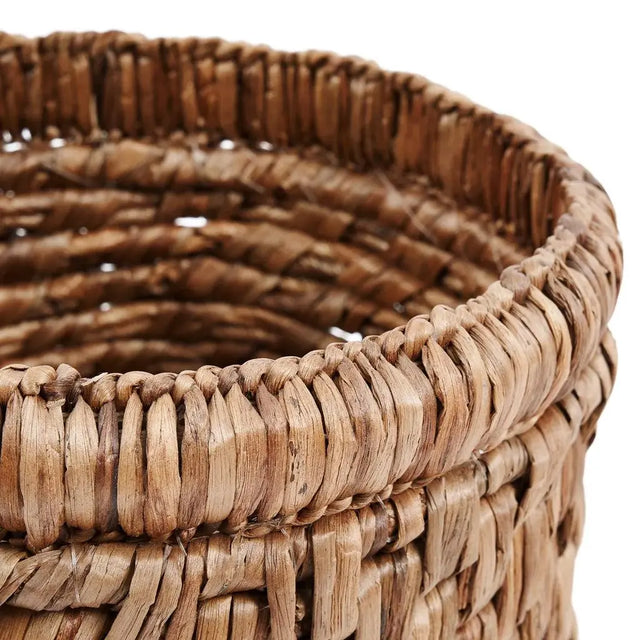 Choppy Mand Laundry Basket on a wooden floor, highlighting its natural water hyacinth texture and spacious design