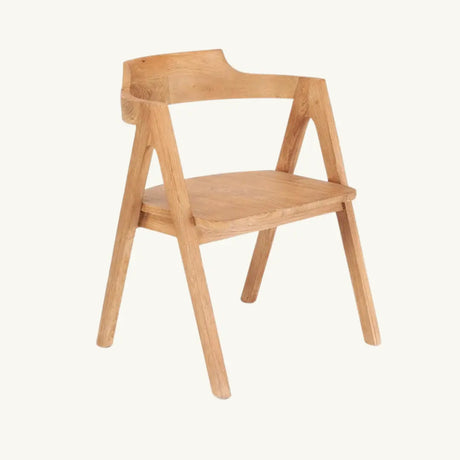 The Nihi Sumba Wood Dining Chair in a front-facing view, showcasing its sharp lines, curved backrest, and natural teak wood finish, perfect for outdoor and indoor use.