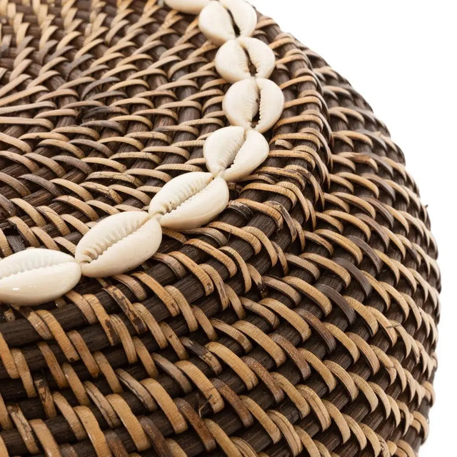 The Colonial Peek-a-Boo Rattan Basket, perfect for organizing coffee capsules or kitchen items, designed with natural brown rattan and decorative cowrie shells.