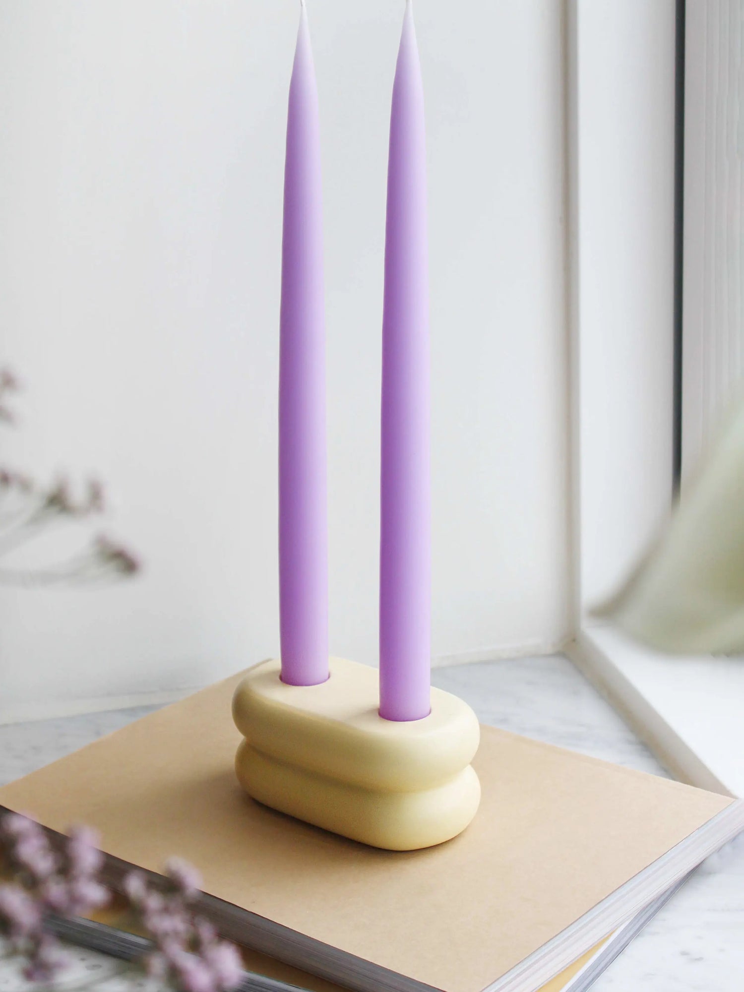 Modern ceramic candlestick with a soft matte yellow finish, featuring a playful rounded curve design