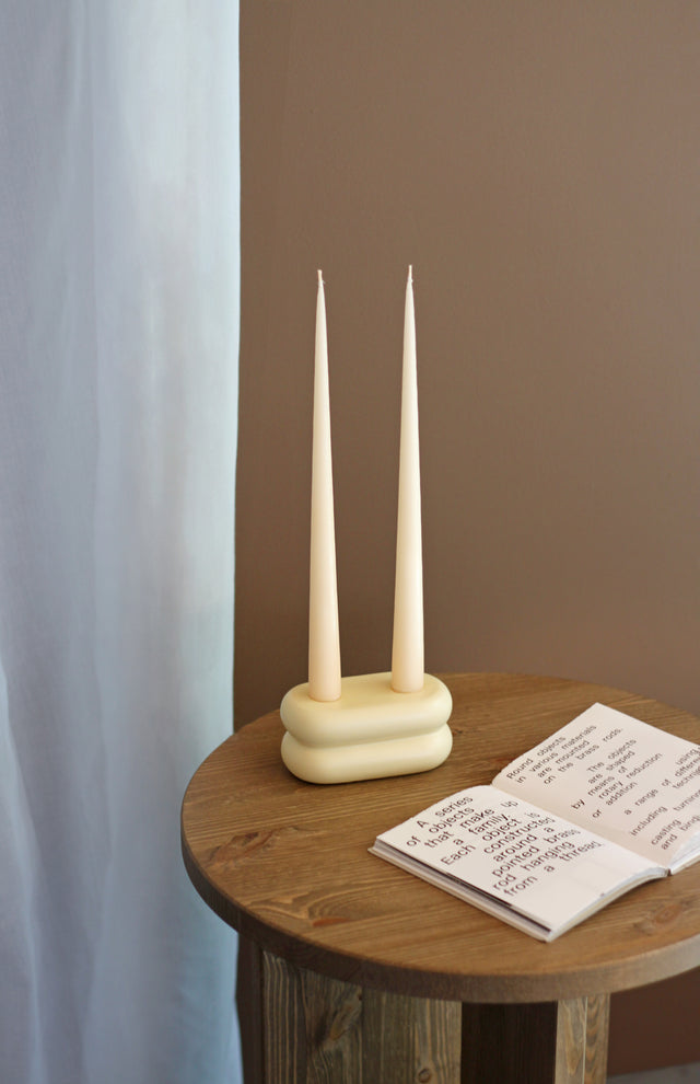 Repeat Candlestick in matte pastel yellow ceramic with rounded curves, holds two candles.