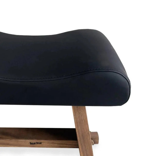 Compact and comfortable stool featuring natural suar wood and sleek black leather, ideal for modern and rustic decor