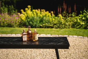 Versatile foldable teakwood dining table with herringbone design and black iron frame, ideal for family meals and gatherings.