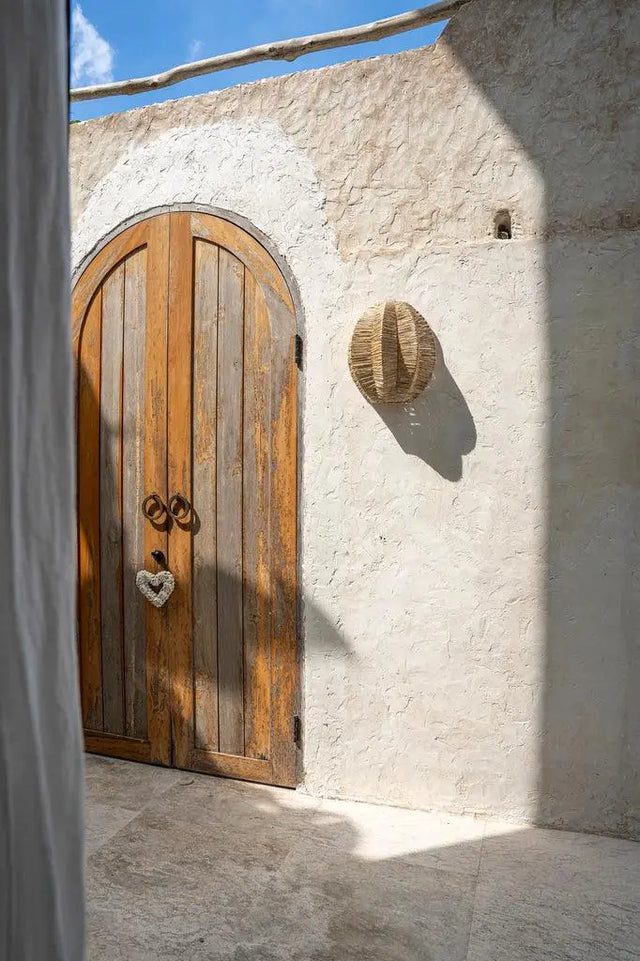 Boho-inspired Avanti wall lamp featuring raffia strands that diffuse light and create a cozy, artistic atmosphere on your walls.