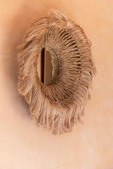 Abaca Round Mirror displayed on a textured wall, highlighting its natural, earthy tones and handcrafted design.