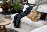 Handwoven black cotton throw with tassels, draped over a sofa, adding warmth and sophistication to the living room