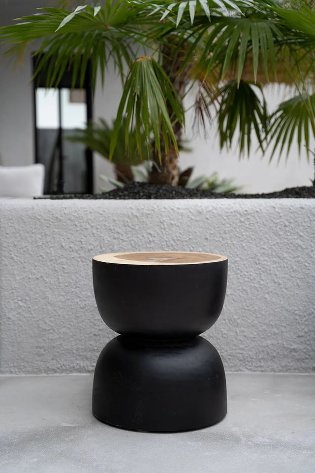 Close-up of the Carbon Crow Stool showcasing its handcrafted black suar wood, smooth round shape, and glossy finish