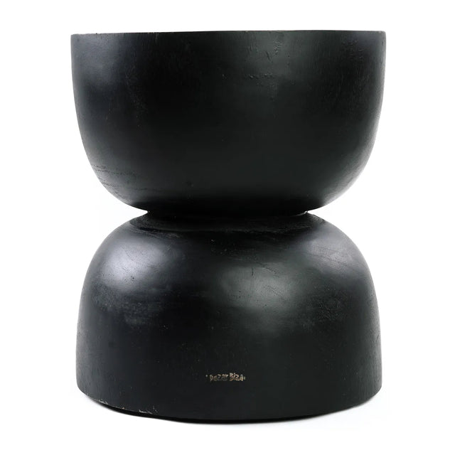 The Carbon Crow Stool featuring natural wood tones and black suar wood, perfect for enhancing modern or bohemian interiors