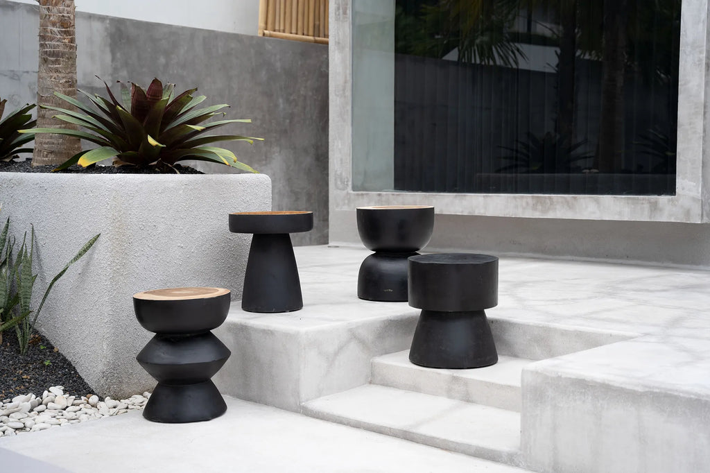 Carbon Crow Stool placed in a covered outdoor area, adding sophistication with its elegant black finish and versatile design