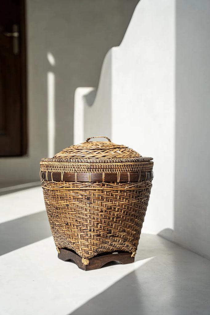 Colonial handcrafted rattan laundry basket with intricate weave design and deep brown accents, durable for storage or decor.